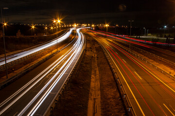 Fototapeta na wymiar Trail of lights left by car headlights on a road at night