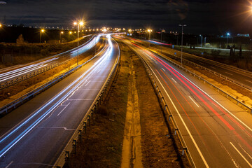 Fototapeta na wymiar Trail of lights left by car headlights on a road at night