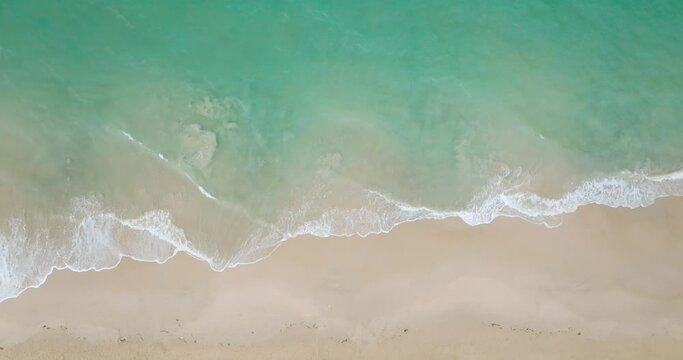 Aerial view video Top-down view beach with sea wave foamy texture water surface beautiful ProRes422