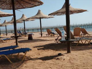 A wonderful beach vacation on a sandy shore with comfortable deck chairs and straw umbrellas