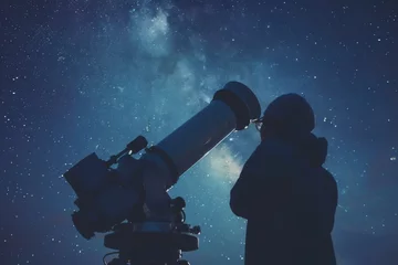 Fototapeten A scientist of any gender, possibly Asian descent, gazing through a large telescope in an observatory against a starry night sky © Nino Lavrenkova