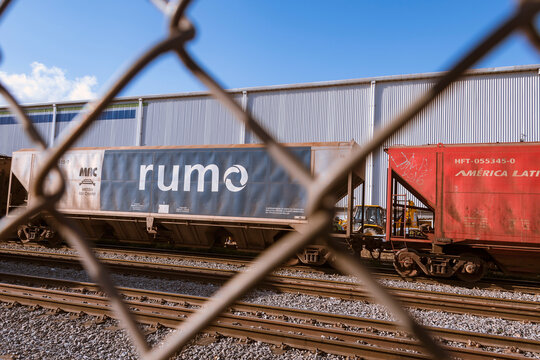 City of Santos, Brazil. Train cars from the company Rumo Logística seen through the security grid passing by the railroad of the Port of Santos.