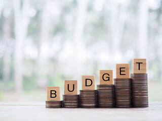 Wooden blocks with the word BUDGET on stack of coins. The concept about budget planning and...