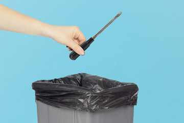throw away the screwdriver, old screwdriver in hand in front of the trash can, the concept is not...