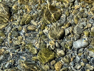 Sea underwater stones pebbles gravel in the clear water.
