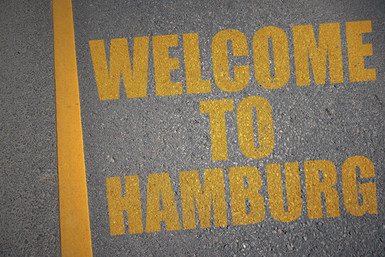 asphalt road with text welcome to Hamburg near yellow line.