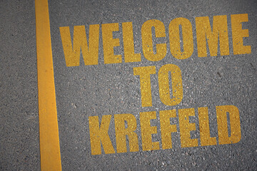 asphalt road with text welcome to Krefeld near yellow line.