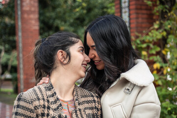 Fototapeta premium portrait of young multiethnic couple latin girlfriends kissing