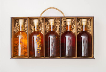 gift set of bottles with brown alcohol whiskey and brandy. Homemade herbal tincture in a wooden box...