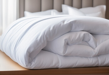 White folded duvet lying on white bed background. Preparing for winter season, household, domestic activities, hotel or home textile. Generative AI