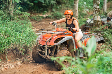 passionate asian woman riding the atv happily spending holiday at atv arena