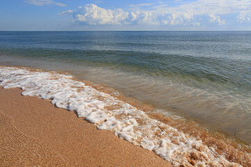 foam on sea sandy shore in sunny day - 719075792