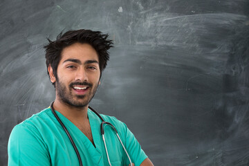 Indian doctor standing next to a blackboard.