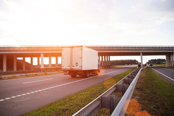 A low-tonnage commercial refrigerated van transports perishable products in the summer on a country...