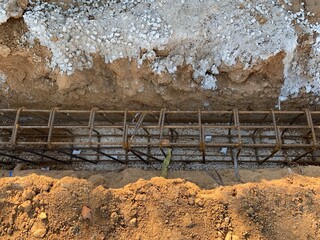 Ground formwork to pour concrete. Monolithic reinforced concrete foundations for the construction of a new building. Rebars for a strip concrete foundation. Steel bars like a mesh for strip footing. 