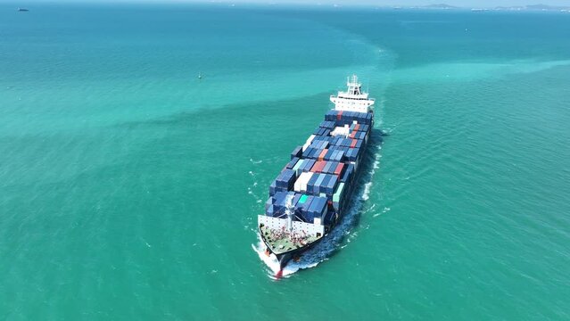 Aerial view of Cargo Container Ship at sunrise. container ship running out of cargo shipyard sea port. export shipping industry freight and transportation logistics concept. commercial shipping by sea
