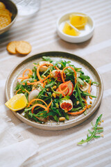 salad with greens, arugula and carrots, light background, daylight, no people, close up