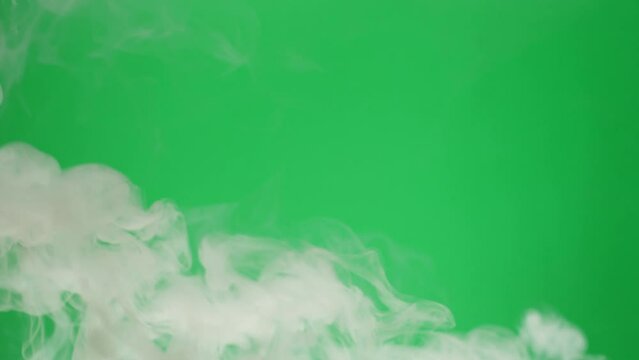 Smoke on green chroma key background. Smoking, steam clouds of vapour close-up. Burning, fog. 