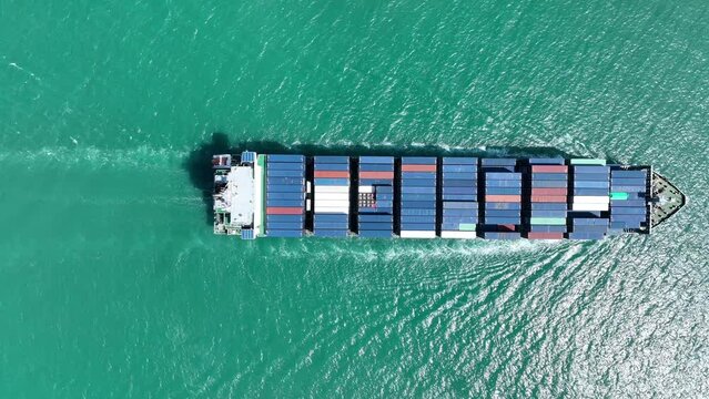 Aerial view of Cargo Container Ship at sunrise. container ship running out of cargo shipyard sea port. export shipping industry freight and transportation logistics concept. commercial shipping by sea