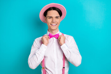 Photo portrait of pretty young male touch fix bow tie wear trendy pink outfit isolated on cyan color background