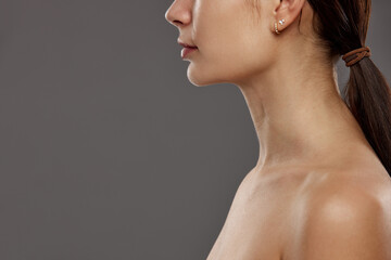 Double chin. Cropped image of female face, profile against studio background. Face lifting,...