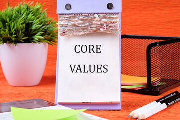 CORE VALUES word written on the page of the desktop calendar on an orange background
