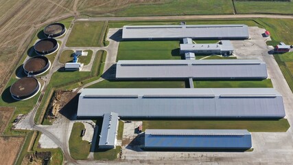 Aerial view of a huge cattle farm located in the countryside amidst fields. Complex of dairy farm buildings: cattle sheds, milking house, washhouse, slaughterhouse. Farm territory.