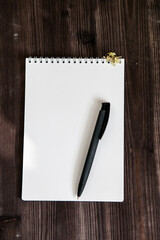 an open white notebook on a dark wooden background