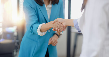 Happy two asian businesswoman making handshake with partner in meeting room, Businesswoman standing...