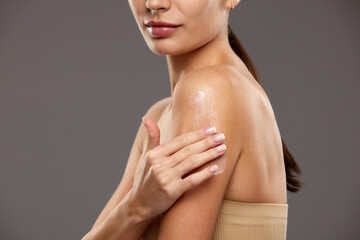 Skincare lotion advertisement focusing on hydration and smooth skin. Cropped image of woman...