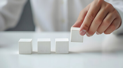 Hand put one of pieces blank white cubes for different concepts on white desk, business, Mockup, Copy space for text.	 - obrazy, fototapety, plakaty
