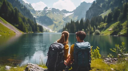 Fotobehang Travelers couple look at the mountain lake with backpacks . Travel and active life concept with team. Adventure and travel in the mountains region with beautiful nature © Hope