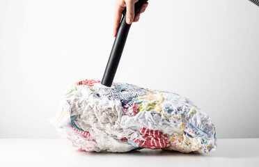 Pumping out air from a vacuum bag with a vacuum cleaner for storing compact-sized items and clothes. Copy space for text