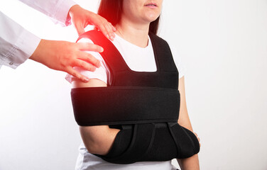 An orthopedic doctor examines a girl patient after a shoulder injury. Bandage on the shoulder joint...