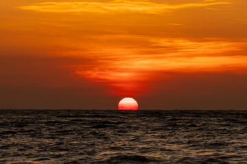 big sun rising over ocean with golden light in early morning at phuket, thailand., 