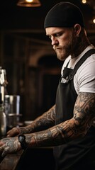 An attractive serious tattooed bearded bartender pours beer, alcoholic drinks in a bar, a nightclub restaurant.