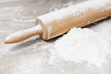 Flour and rolling pin on a wooden table