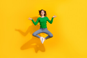 Fototapeta na wymiar Full body length photo of relaxed woman in sweater denim jeans jumping peace practicing meditation isolated on yellow color background
