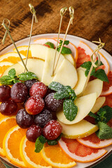 Fruit salad with apples, grapefruits and oranges on wooden table