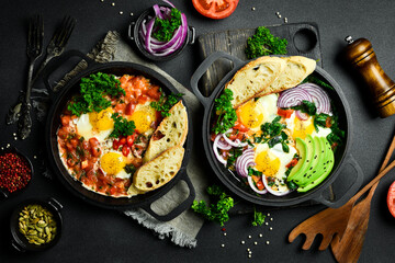 Fried eggs with vegetables: tomatoes, paprika, peppers, onions. Vegetable Shakshuka in a pan. Top view. Free space for your text. - obrazy, fototapety, plakaty