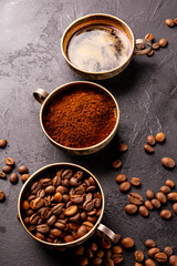Coffee vertical background - cup of black coffee, coffee beans and ground coffee on a black background