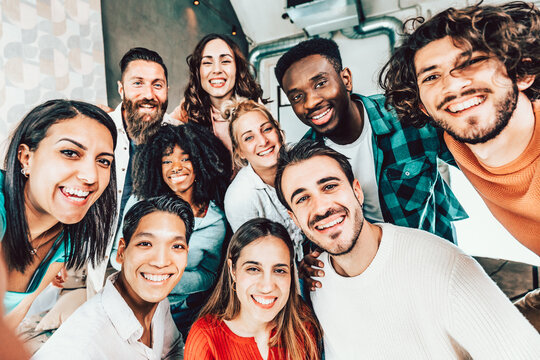 Multiracial friends taking group selfie shot at camera - Happy young people smiling together at smart mobile phone device at home - University students having fun together in college campus