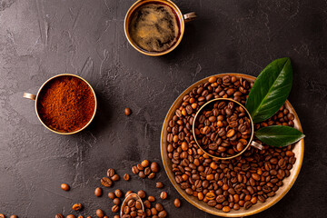 Coffee background - cup of black coffee, coffee beans and ground coffee on a black background top view, copy space for text