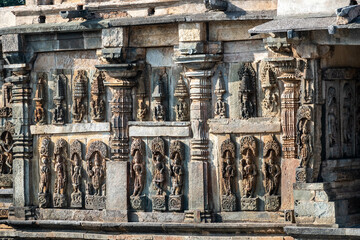 Beautiful intricate patterns and carvings of figurines on the wall of the ancient Chennakeshava temple in Belur, Karnataka.