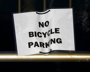 NO BICYCLE PARKING sign on a guard rail