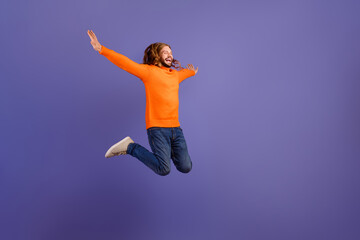Full body length photo of young funny positive man hipster carefree catch freedom flying in air wings isolated on violet color background