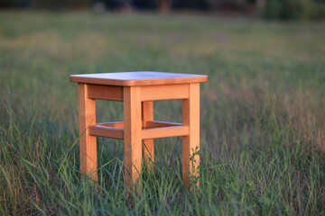 wooden stool on meadow - 719236711