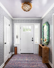 An entryway mudroom detail with wallpaper, a purple ceiling and gold light fixture, and a white doorway and windows. - obrazy, fototapety, plakaty