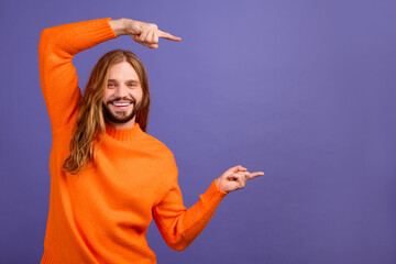 Portrait of attractive model man wear orange jumper pointing two fingers empty space family brand...