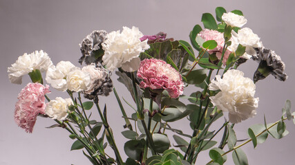 Beautiful bouquet of pink, grey and white carnation flowers, fresh eucalyptusas and violet brassica flower.